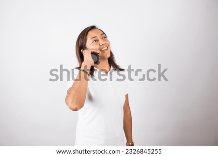 photo of latin woman talking on the phone with gestures on a light background. Concept of people and emotions.