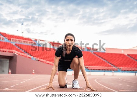 Asian young sportswoman sprint on a running track outdoors on stadium. Attractive strong athlete girl runner exercise and practicing workout speed running marathon on the race for olympics competition Royalty-Free Stock Photo #2326850993