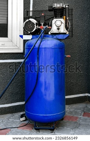 Blue piston air compressor, used outdoor. Royalty-Free Stock Photo #2326856149