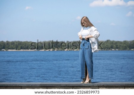 Full body portrait of a young beautiful blonde girl in long blue jeans skirt Royalty-Free Stock Photo #2326859973