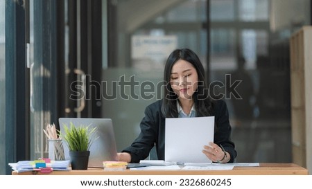 Asian Businesswoman working on a laptop at her desk at the office.