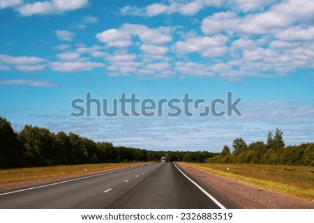 highway going into the distance. Gorgeous view of highway going into distance through forests against background of blue sky with white clouds. Royalty-Free Stock Photo #2326883519