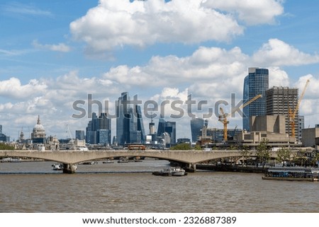 View East down the river Thames in London towards St Paul's Cathedral and the City of London from the Golden Jubilee footbridges on a warm summer day