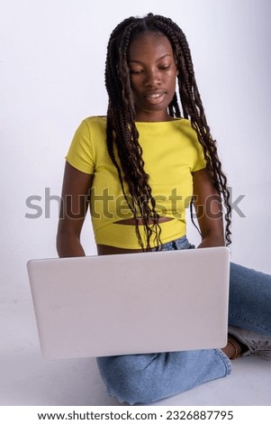 Full body young colored smiling happy fun cool IT woman wait use work on laptop pc computer isolated on a white background studio portrait.