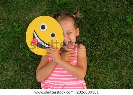 Cute beautiful girl making a grimace repeating after a smile face showing her tongue.