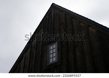 Shou Sugi Ban or surface charred wood cladding on a building with one window Royalty-Free Stock Photo #2326895557