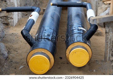 Construction and installation of the Pre-insulated hot water pipeline and connections to hot water station. Greening and  Efficiency of heat supply. Ongoing construction. Energy distribution.  Royalty-Free Stock Photo #2326904425