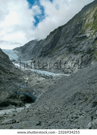 The picture shows the Franz Josef Glacier on the South Island of New Zealand on a slightly cloudy day. 