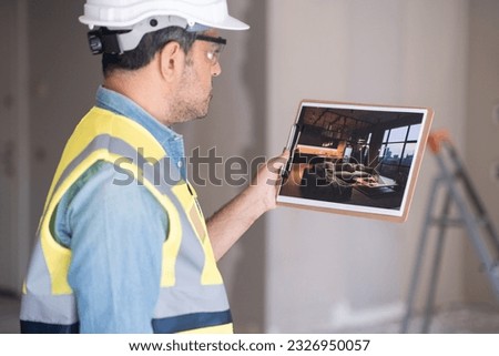 Pensive worker holding picture of modern interior design in loft style in hand standing against ladder in unfinished room man imagining apartment after renovation
