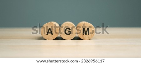 Wooden blocks with the word AGM - Annual general meeting. Mandatory yearly gathering of a company's interested shareholders. Annual report. Company's performance and strategy. Business concept Royalty-Free Stock Photo #2326956117
