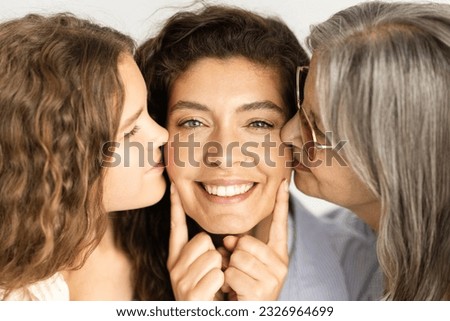Happy european old and teen woman and girl kiss adult lady on cheeks, isolated on white background, studio, close up. Female generation, love, family relationships and genetic