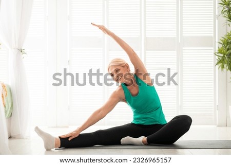 Pilates For Mature Adults. Sporty Senior Woman Making Stretching Exercises At Home, Happy Beautiful Elder Female In Activewear Training On Fitness Mat In Light Living Room, Copy Space