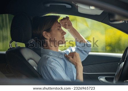Tired middle aged woman driver feeling bad, having headache, nausea healthy problems driving car. Female with closed eyes touching head, breast, side view. Loss of consciousness, heart attack concept. Royalty-Free Stock Photo #2326965723