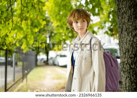 Adorable young girl having fun on beautiful summer day. Teenager portrait in summer park. Teen girl outdoors.