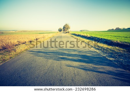 vintage photo of rural landscape with asphalt road