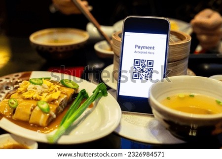 Customer hand using smart phone to scan QR code tag with blurry fresh spring rolls or chinese food to accepted generate digital pay without money. Qr code payment concept.