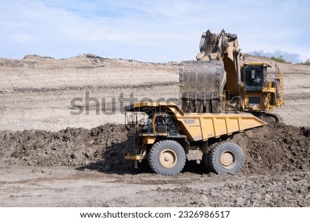 over burden loading in coal mine from excavator into truck, coal mine industry Royalty-Free Stock Photo #2326986517