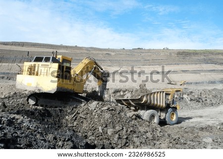 over burden loading in coal mine from excavator into truck, coal mine industry Royalty-Free Stock Photo #2326986525