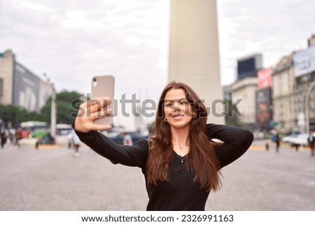 beautiful latin american woman taking selfies at the Obelisk of Buenos Aires