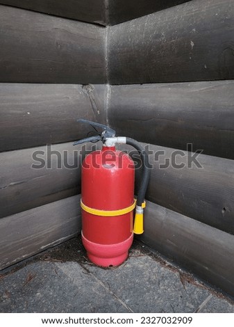 A fire extinguisher is placed next to the house