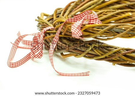 Beautiful textured Christmas wreath made from intertwined vine branches Natural white background enhances the rustic charm Selective focus emphasizes the intricate details of the wreath