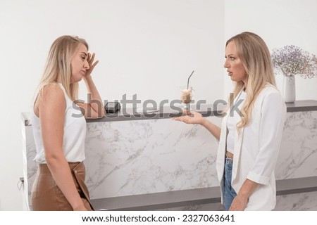 Dissatisfied client stands at the reception of a beauty salon. 