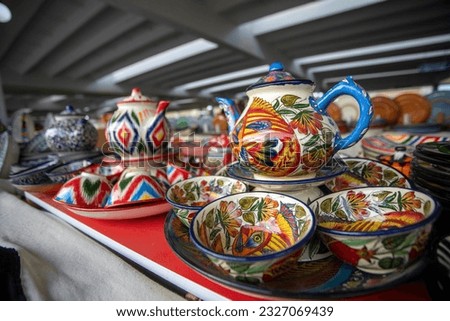 Ceramic tea set with colorful patterns and depiction of fish.