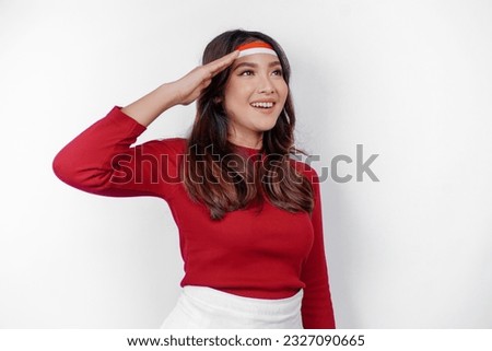 Beautiful Asian woman giving salute celebrate Indonesian independence day on August 17 isolated over white background Royalty-Free Stock Photo #2327090665