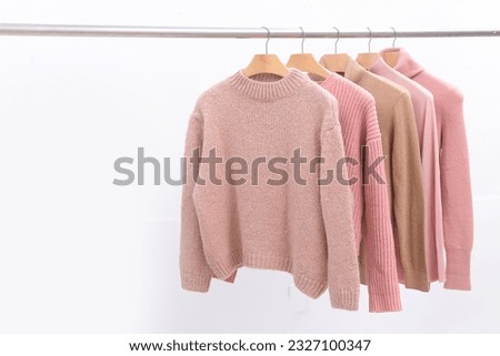 Row of Knitted, turtleneck sweaters hang on hangers. Bright sweaters.. Fashion. Royalty-Free Stock Photo #2327100347