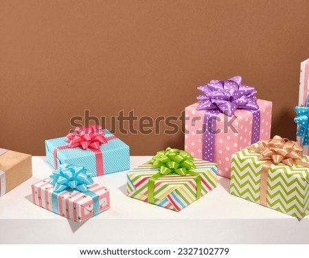 Holiday composition with beautiful gifts. Birthday surprise. Colored gift paper with pictures and gift bows.