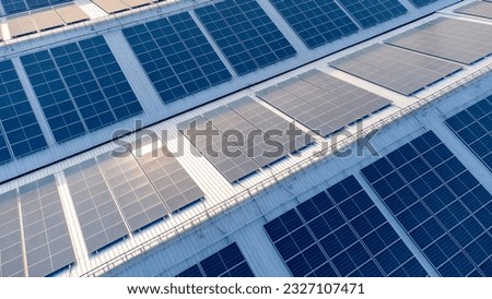 Future green energy and sustainable electricity resource concept. Outdoor focus on solar panels on rooftops or photovoltaics of factories by drone. Industrial roof with solar cell grid with blue tone. Royalty-Free Stock Photo #2327107471