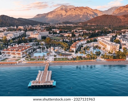 mesmerizing aerial view, capturing a picturesque panorama of hotels, sandy beaches, and majestic mountains meeting the sea Royalty-Free Stock Photo #2327131963