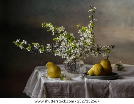 Still life with branches of cherry blossoms and pears on a dark background.