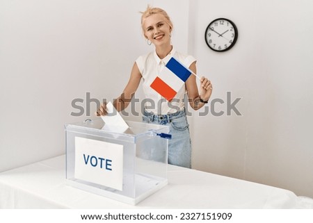 Young blonde woman holding french flag voting at electoral college