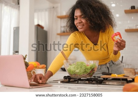 Multiracial young woman cooking salad at home.