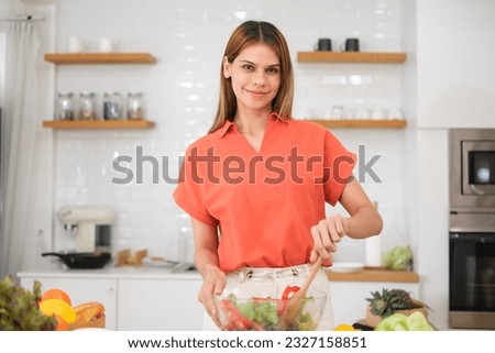 Multiracial young woman cooking salad at home.