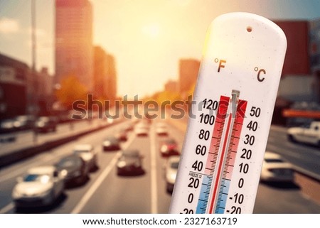 Thermometer in front of cars and traffic during heatwave Royalty-Free Stock Photo #2327163719
