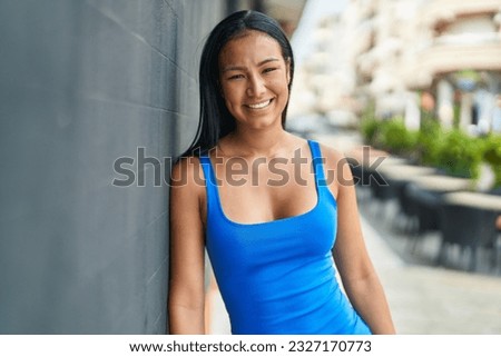 Young beautiful latin woman smiling confident standing at street