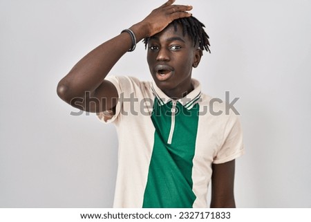 African man with dreadlocks standing over isolated background surprised with hand on head for mistake, remember error. forgot, bad memory concept.  Royalty-Free Stock Photo #2327171833