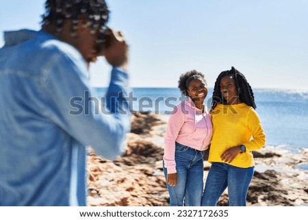 African american friends hugging each other making photo at seaside