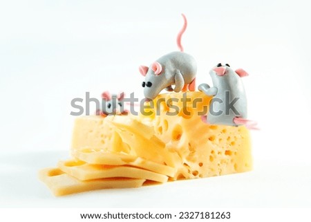 Little plasticine mice and a piece of cheese with holes. White background.