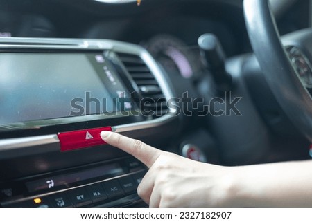 Close up woman hand is pressing the emergency light button in the car, Open the contract emergency light in car. Emergency button. road accident, Road traffic injuries, ask for help, safety concept.