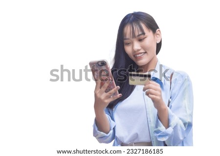 Professional Asian business woman in a blue shirt smiles happily successful in the city while holds smartphone and credit card among isolated on white background.