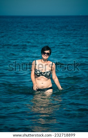 Young happy woman walking in sea.