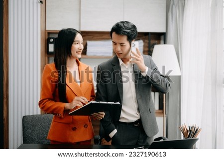 Two Asian businesswoman discuss investment project working and planning strategy with tablet laptop computer in modern office.