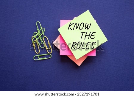 Know the rules symbol. Yellow steaky note with paper clips with words Know the rules. Beautiful deep blue background. Business and Know the rules concept. Copy space.
