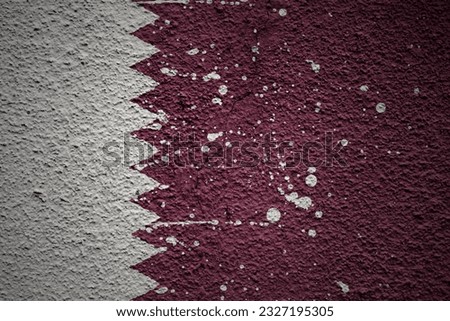 colorful painted big national flag of qatar on a massive old cracked wall