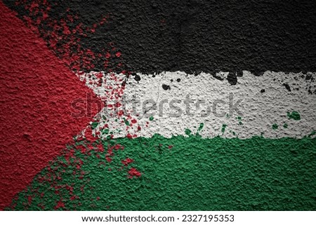 colorful painted big national flag of palestine on a massive old cracked wall