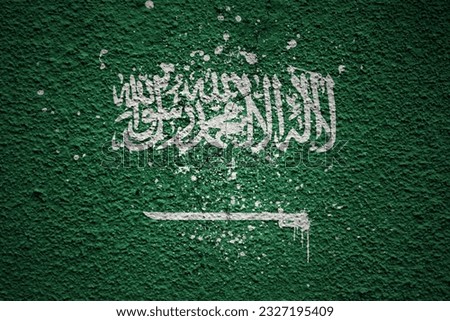 colorful painted big national flag of saudi arabia on a massive old cracked wall
