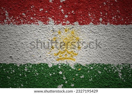 colorful painted big national flag of tajikistan on a massive old cracked wall